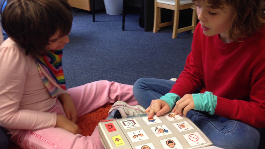 siblings interacting using a PODD communication book